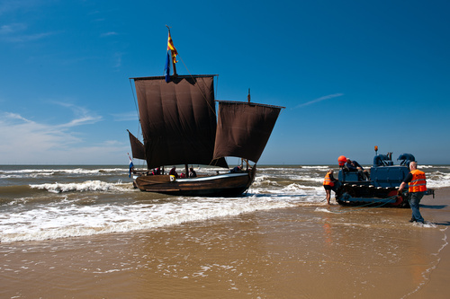 Onder vol zeil op het strand zetten van de Pinck na de tocht vanuit Scheveningen